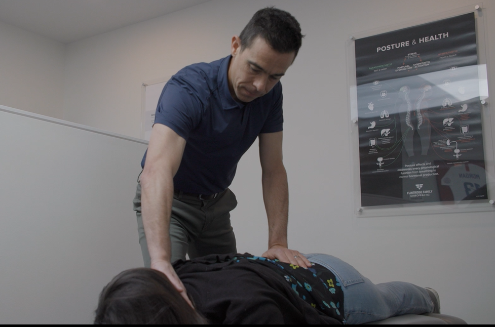 Chiropractic adjustment in a posture & health-themed treatment room at Flintridge Family Chiropractic